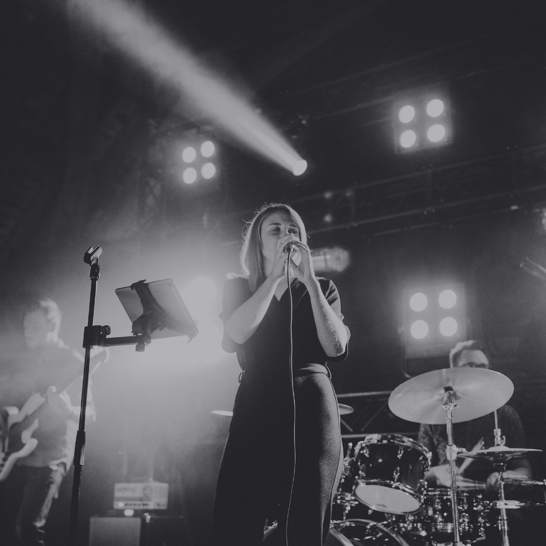 Live wedding band performing on stage at Cotswolds wedding reception with dramatic lighting