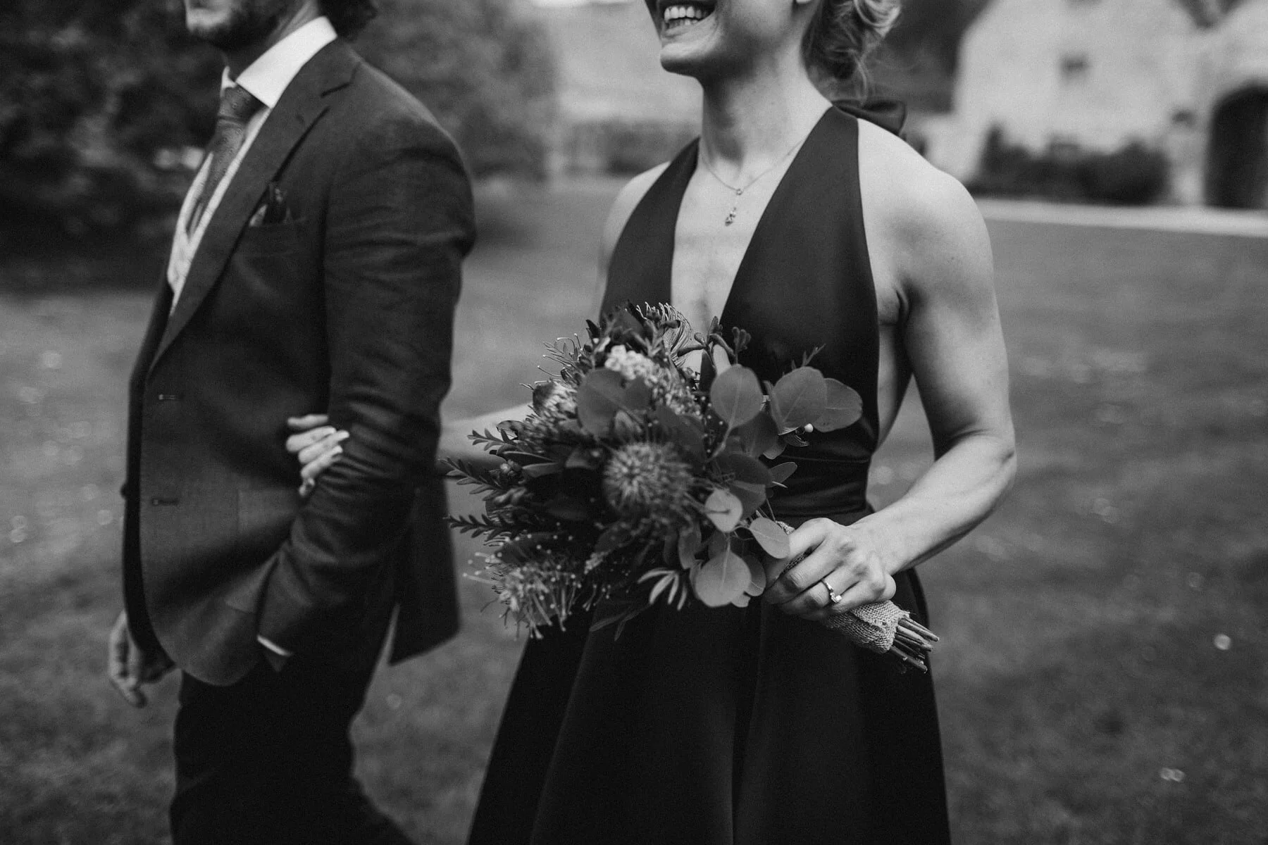 Smiling Bride in halterneck dress holding bouquet at Cotswolds wedding
