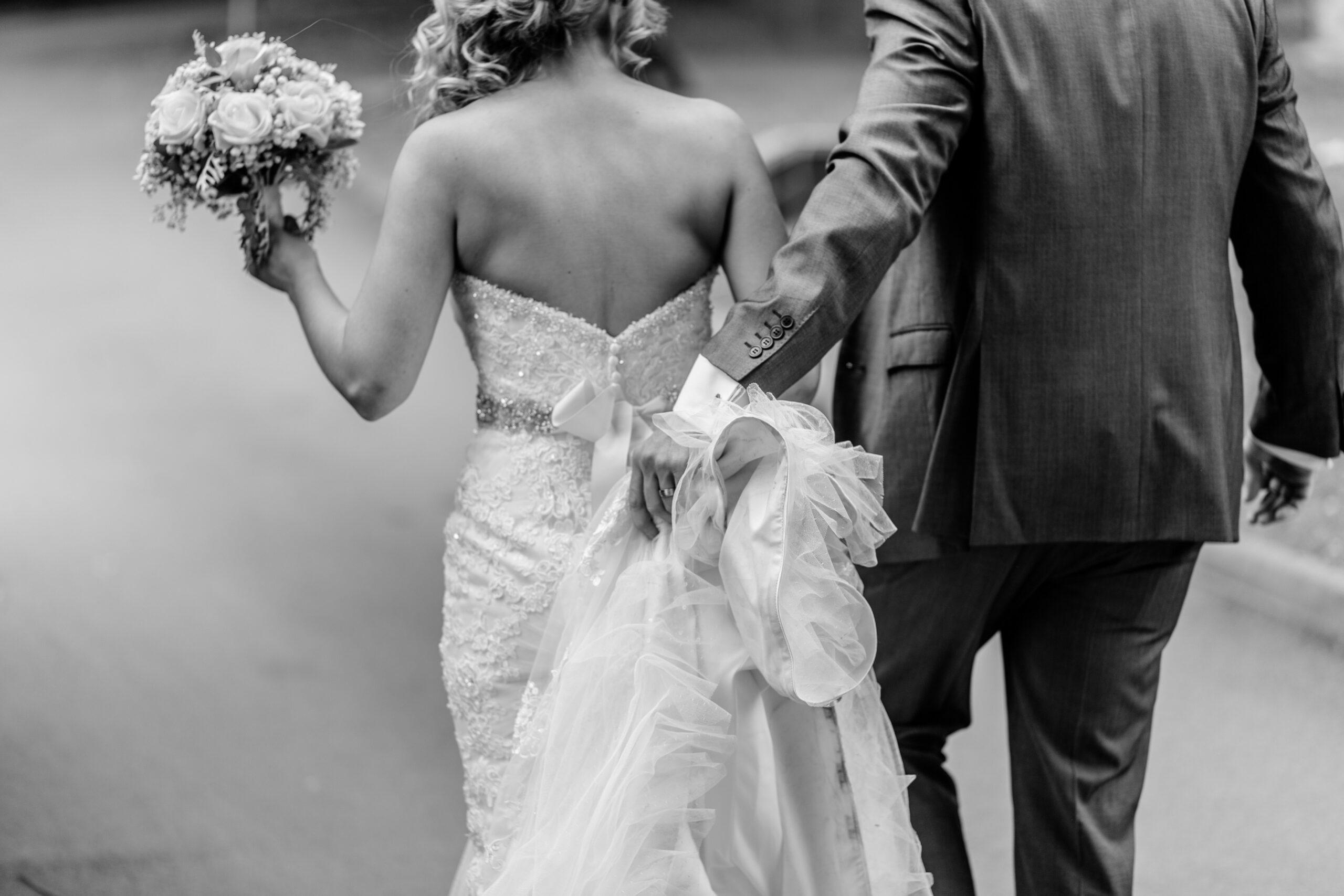 Back detail of bride's intricate lace and ruffle wedding gown at Cotswolds wedding