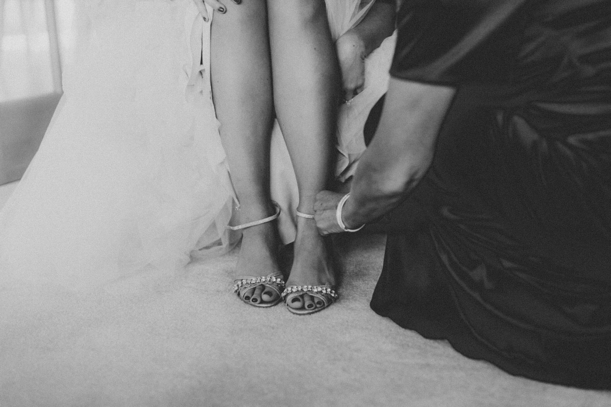 Close-up detail of bride's strappy heeled sandals at Cotswolds wedding